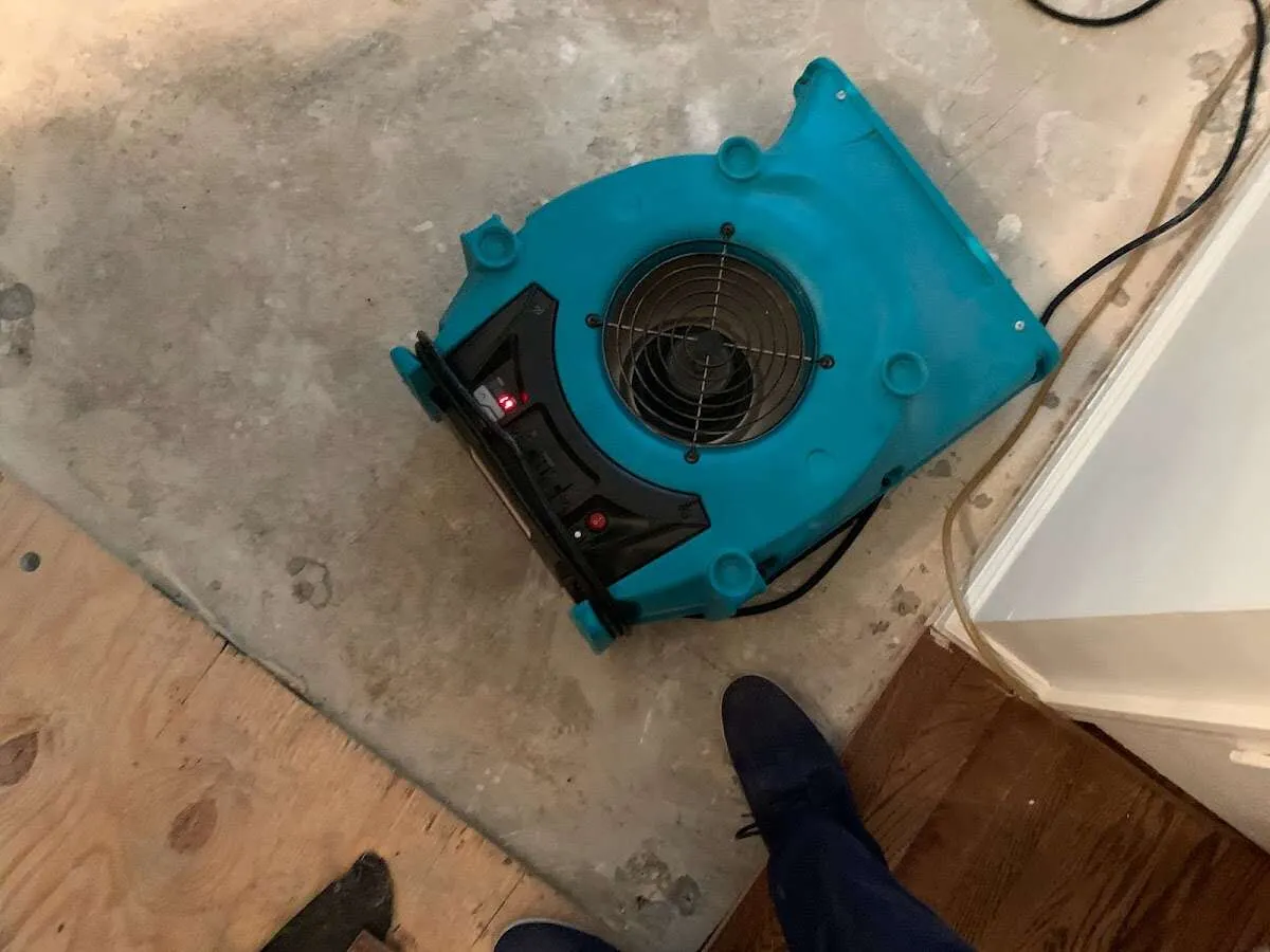 Air mover drying subfloor during Commercial Water Damage Restoration in Derby